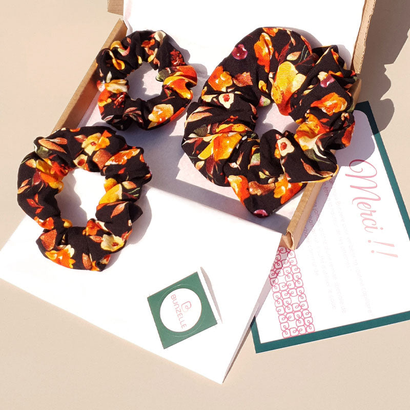 Ensemble de 3 chouchous cheveux noirs à fleurs orangées dans leur packaging Bunzelle